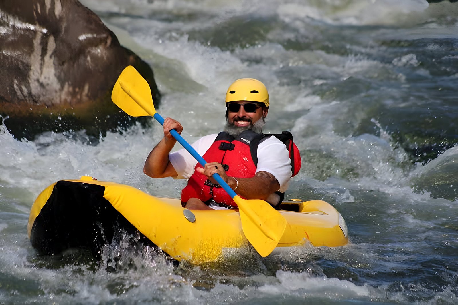 Kayaker paddling through white-water rapids